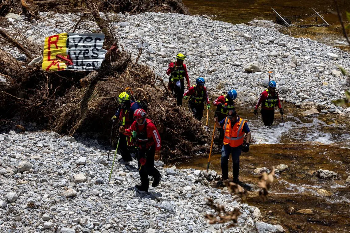 Search and rescue team members look for missing people amid debris in the waters of the Guadalupe River, near Camp Mystic, following deadly flooding, in Hunt, Texas, US on July 10, 2025.