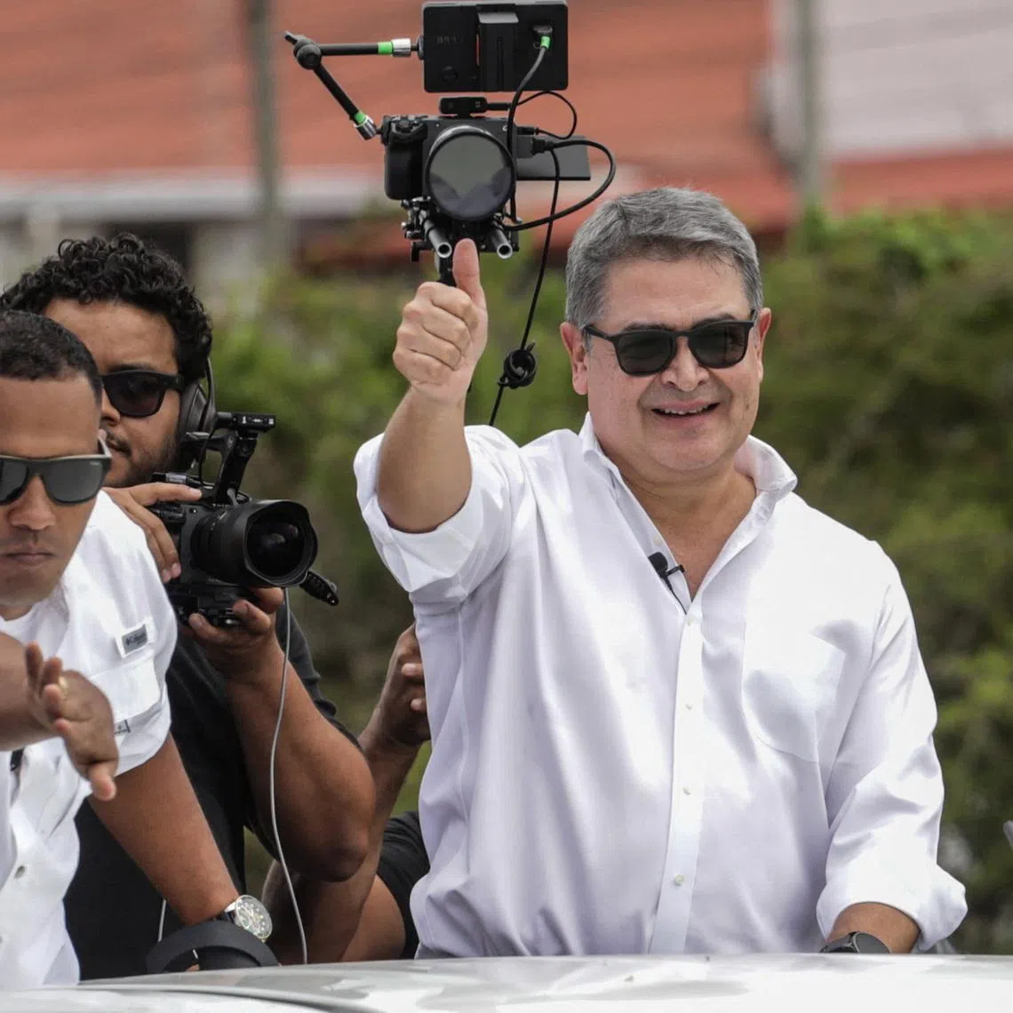Former Honduran President Juan Orlando Hernandez gives a thumbs up from a vehicle upon his arrival at Palmerola International Airport following a pardon by U.S. President Donald Trump, which freed Hernandez from a 45-year prison sentence for conspiring to import cocaine into the United States, near Comayagua, Honduras, July 26, 2026. REUTERS/Fredy Rodriguez