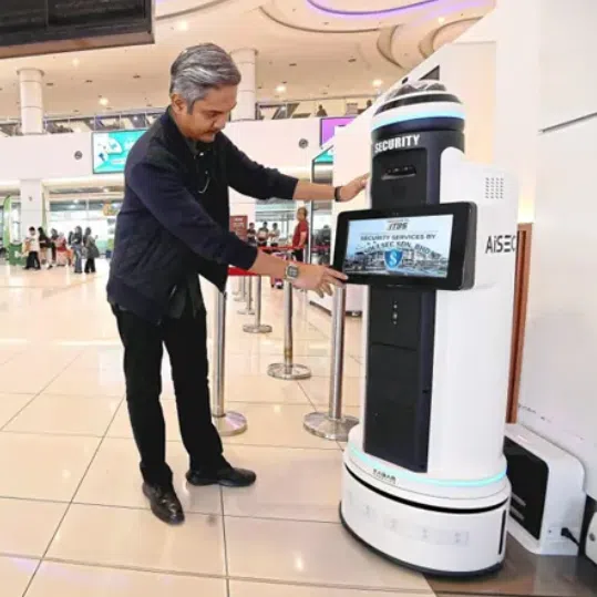 A TBS staff member prepping the security robot for official trial. 