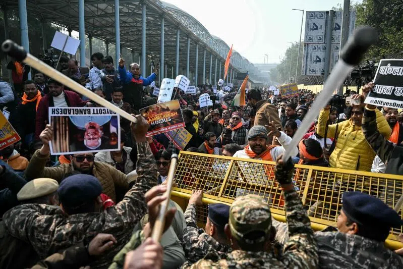 Security personnel try to stop protestors rallying against the killing of Dipu Chandra Das, near the Bangladesh High Commission in New Delhi on Dec 23.
