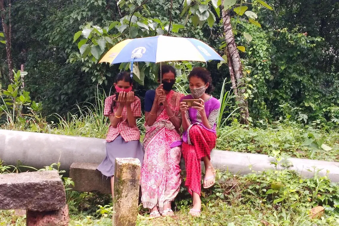 A woman and children studying with a smartphone at a Wi-Fi hot spot in Sullia, India’s Karnataka state.