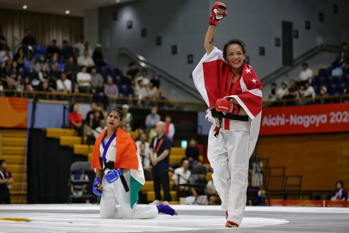Tiffany Teo of Singapore raising her fist, while a disconsolate Suchika Tariyal of India sank to her knees, after being announced the winner of the mixed martial arts women's tradition (60kg) semifinal of the Aichi-Nagoya 2026 Asian Games at the Nagoya City Inae Sports Centre in Nagoya, Japan on Sept 21, 2026. ST PHOTO: KEVIN LIM pixag21