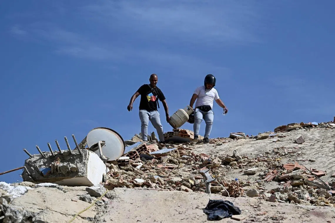 Residents recovering a gas cylinder from a collapsed building in Caraballeda, in Venezuela’s La Guaira state, on June 25.