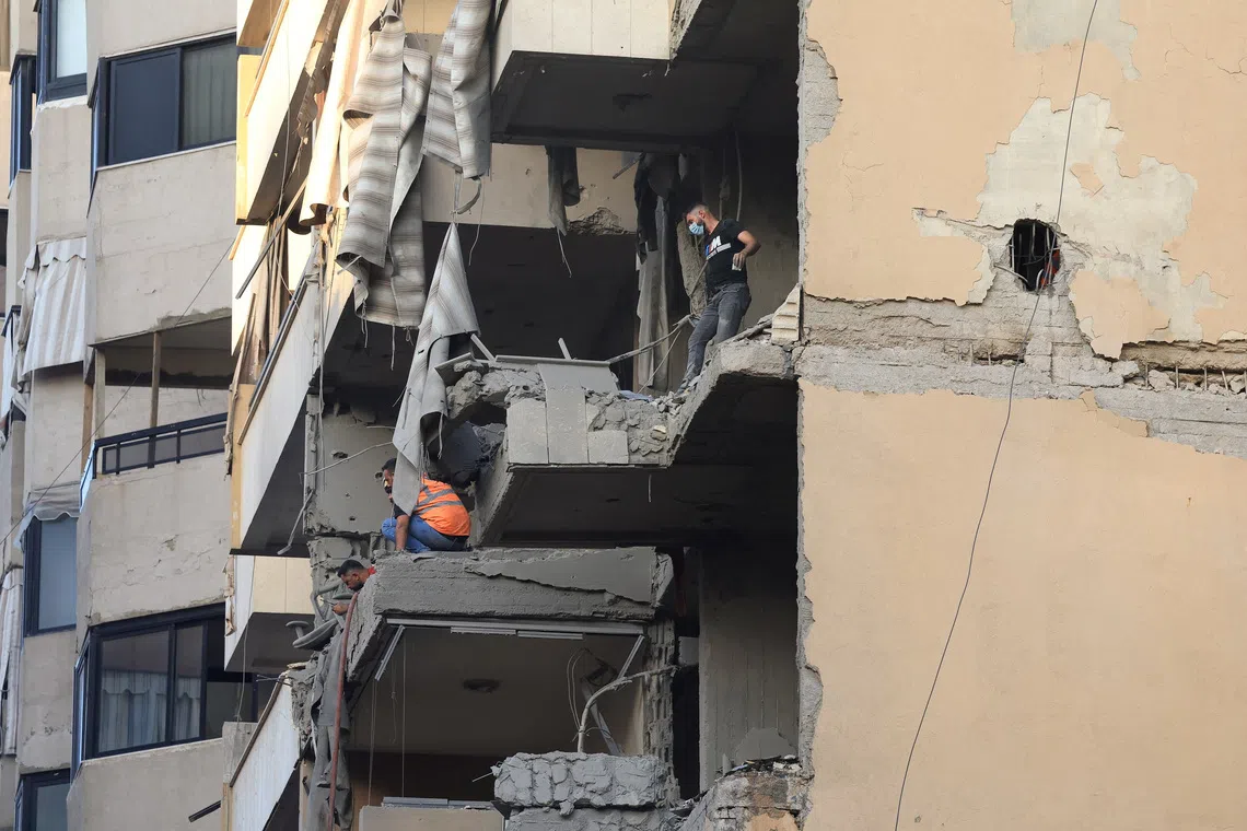 People inspect a damaged building, after Israeli military said on Sunday that it struck a militant from the Lebanese Iran-aligned Hezbollah group, in Beirut's southern suburbs, Lebanon November 23, 2025. REUTERS/Mohamed Azakir