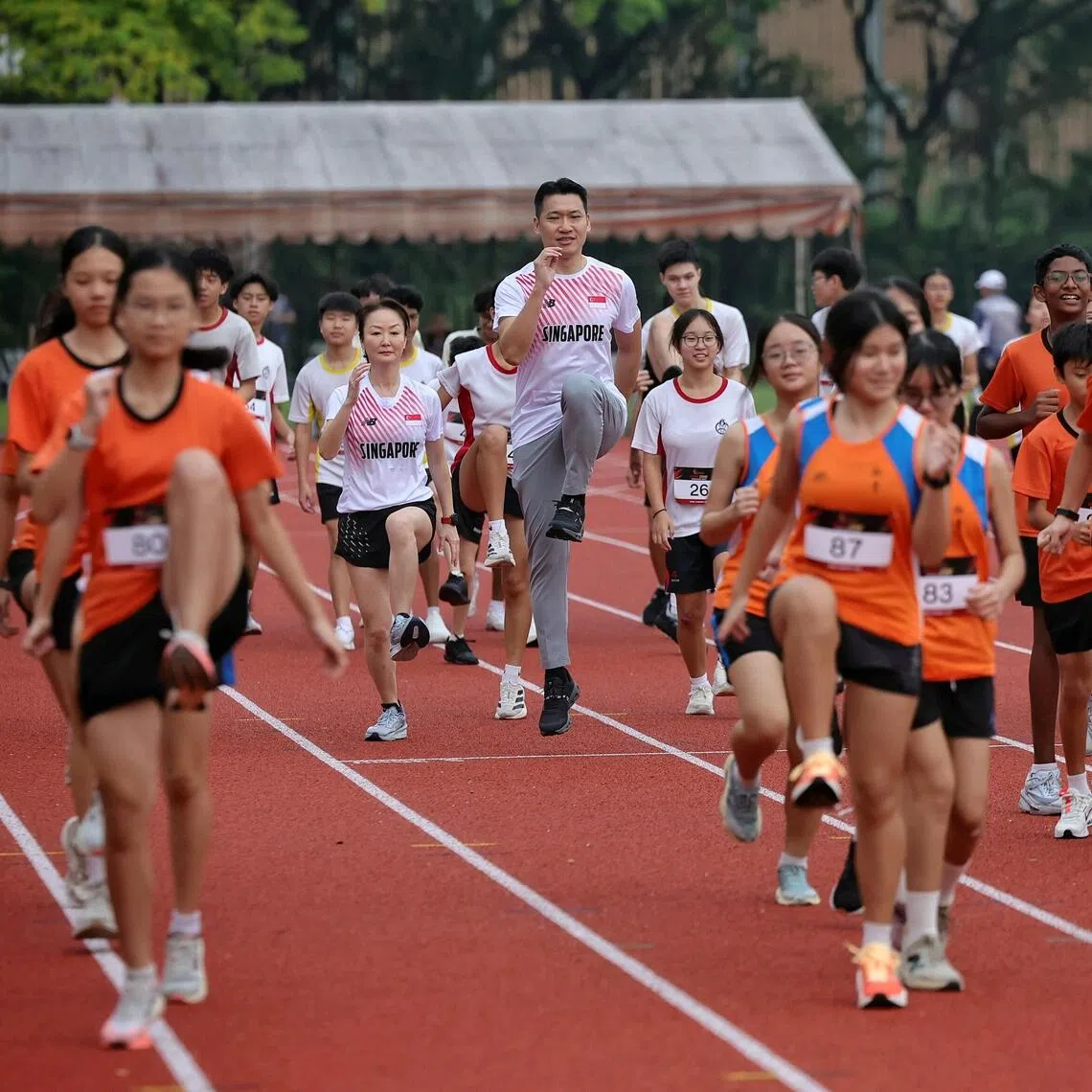 Minister for Culture, Community and Youth David Neo (centre) joining students for a warm-up ahead of the competition at the West Zone Athletics Meet at Hwa Chong Institution on Oct 26.