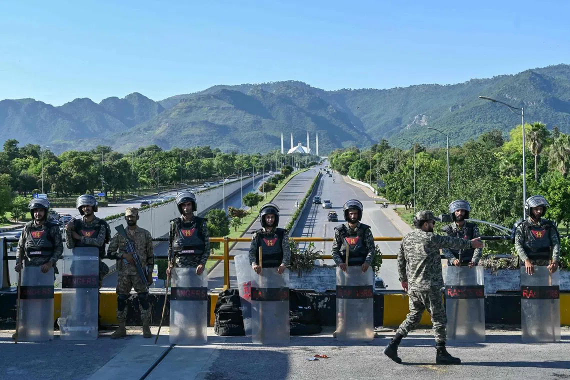Pakistan Rangers standing guard as a precaution against former Prime Minister Imran Khan's supporters and activists amid protests in Islamabad on Oct 6. Pakistan's capital was locked down on Oct 5, swarmed by security forces with mobile internet cut as supporters of jailed ex-prime minister Khan attempted to seize the streets in protest.