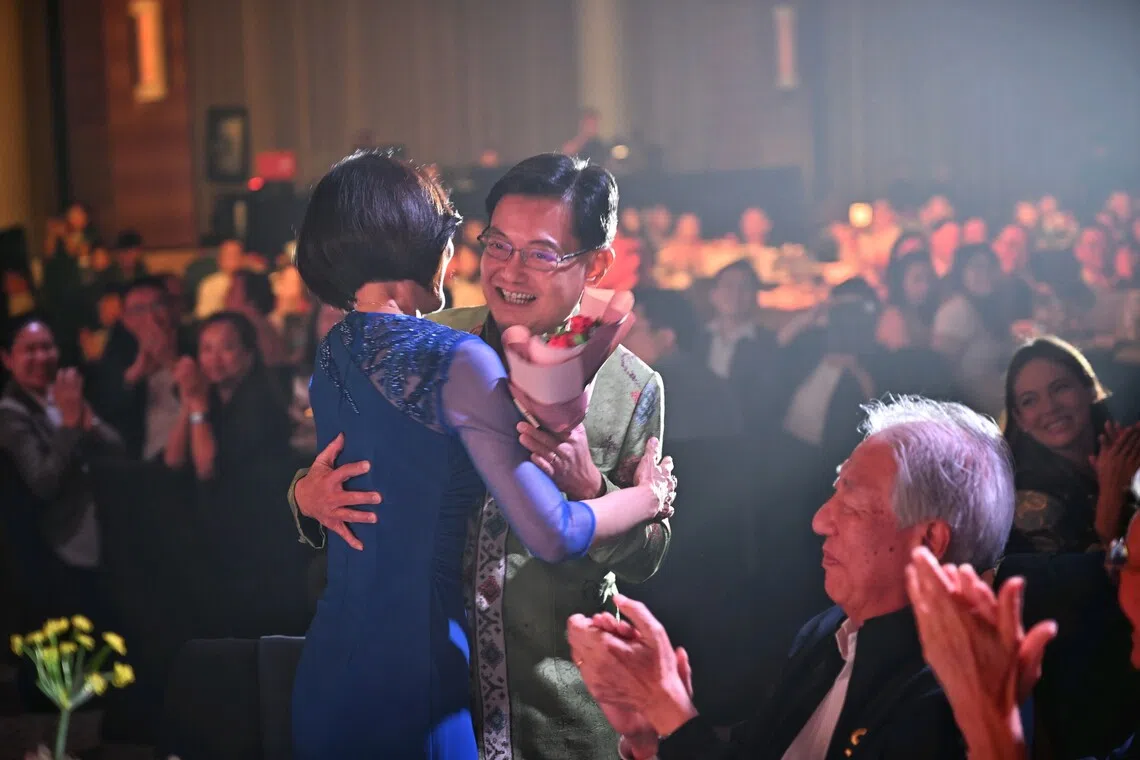 Former deputy prime minister Heng Swee Keat presenting his wife, Madam Chang Hwee Nee, with a bouquet of red roses at the end of his tribute.