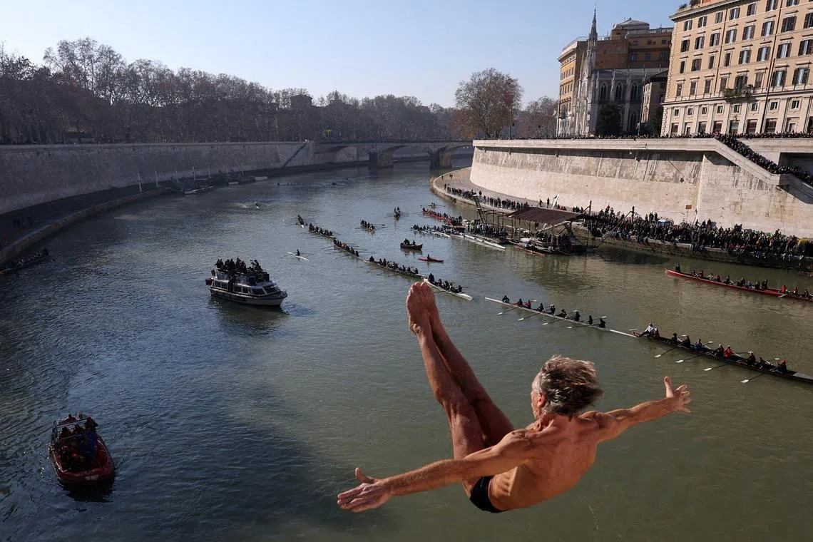 FILE PHOTO: Marco Fois dives into the Tiber River from the Cavour bridge, as part of traditional New Year celebrations, in Rome, Italy, January 1, 2025. REUTERS/Claudia Greco/File Photo