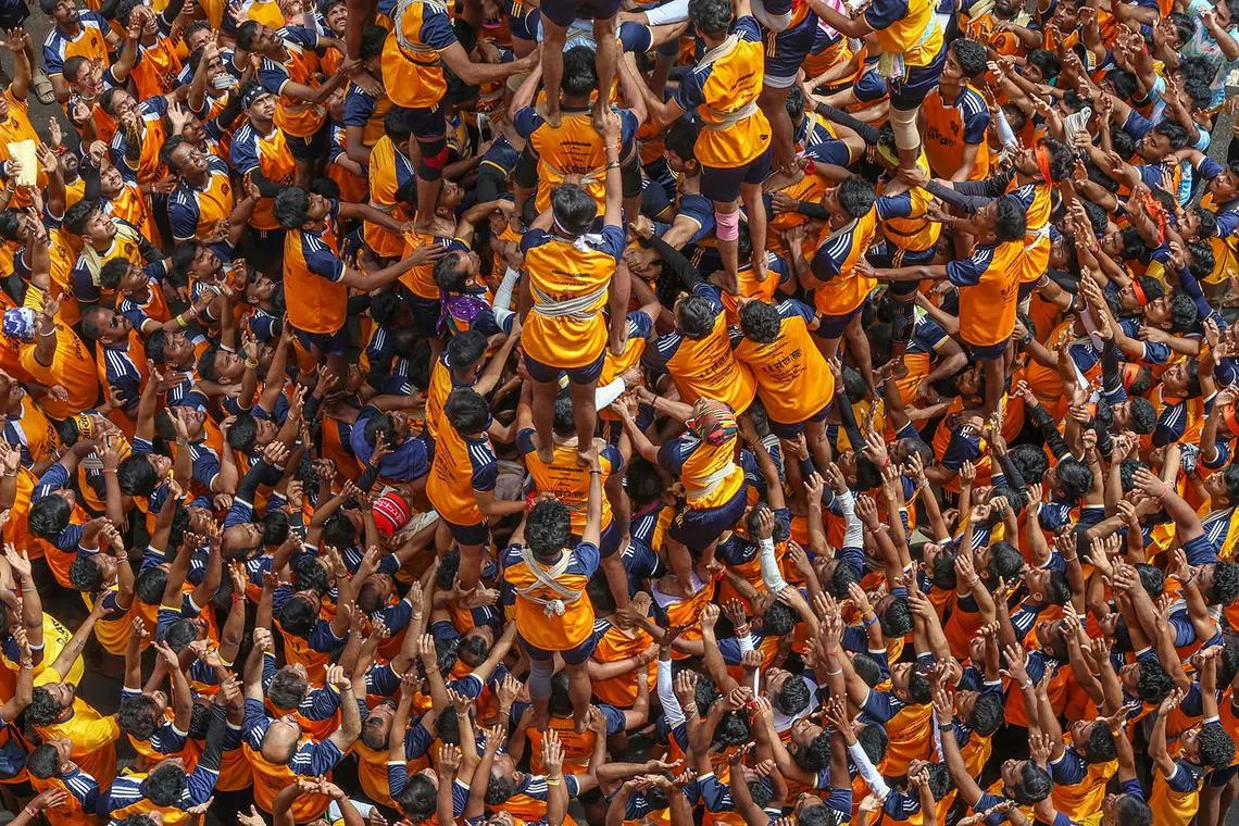 Hindu devotees forming a human pyramid to reach and break a curd pot, on the occasion of the Janmashtami Festival in Mumbai, India, Aug 27, 2024. 