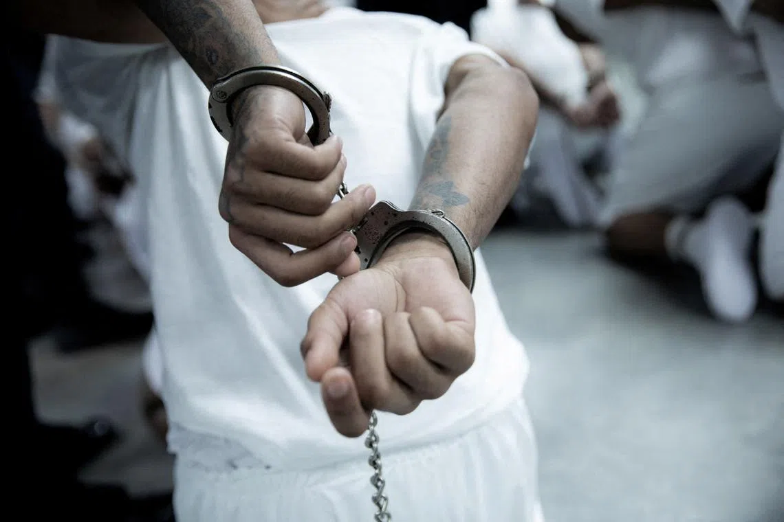 Salvadoran police officers escort an alleged member of the Venezuelan gang Tren de Aragua recently deported by the U.S. government to be imprisoned in the Terrorism Confinement Center (CECOT) prison, as part of an agreement with the Salvadoran government, in Tecoluca, El Salvador, in this handout image obtained March 16, 2025. Secretaria de Prensa de la Presidencia/Handout via REUTERS/File Photo