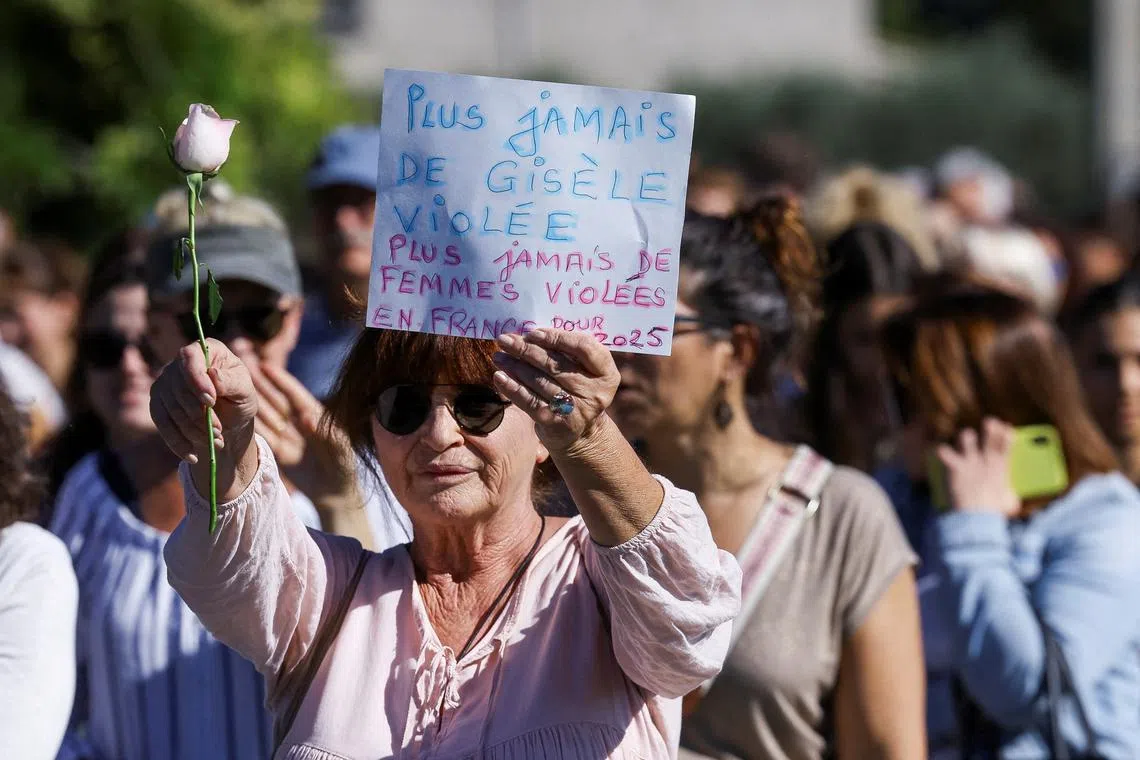 A woman holds a sign that reads \"No more Gisele raped, no more women raped in France\" in Mazan, France, October 5, 2024. REUTERS/Manon Cruz/File Photo