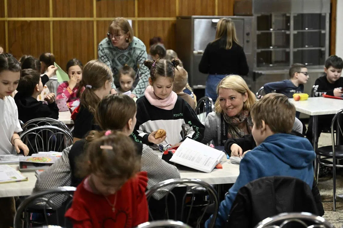 Children study in an air-raid shelter in the cellar of a school after an alarm signal in Kyiv on March 23.