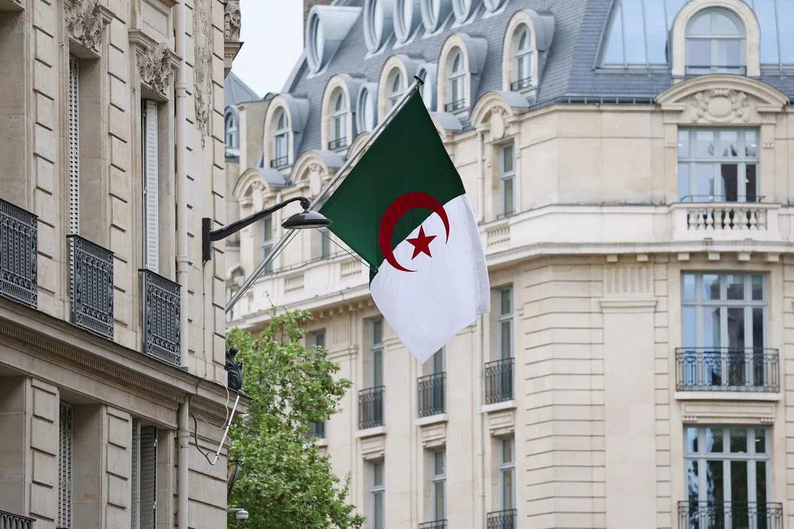 FILE PHOTO: The Algerian flag flies on the facade of the Algerian Embassy in Paris, France, April 16, 2025. REUTERS/Gonzalo Fuentes/File Photo