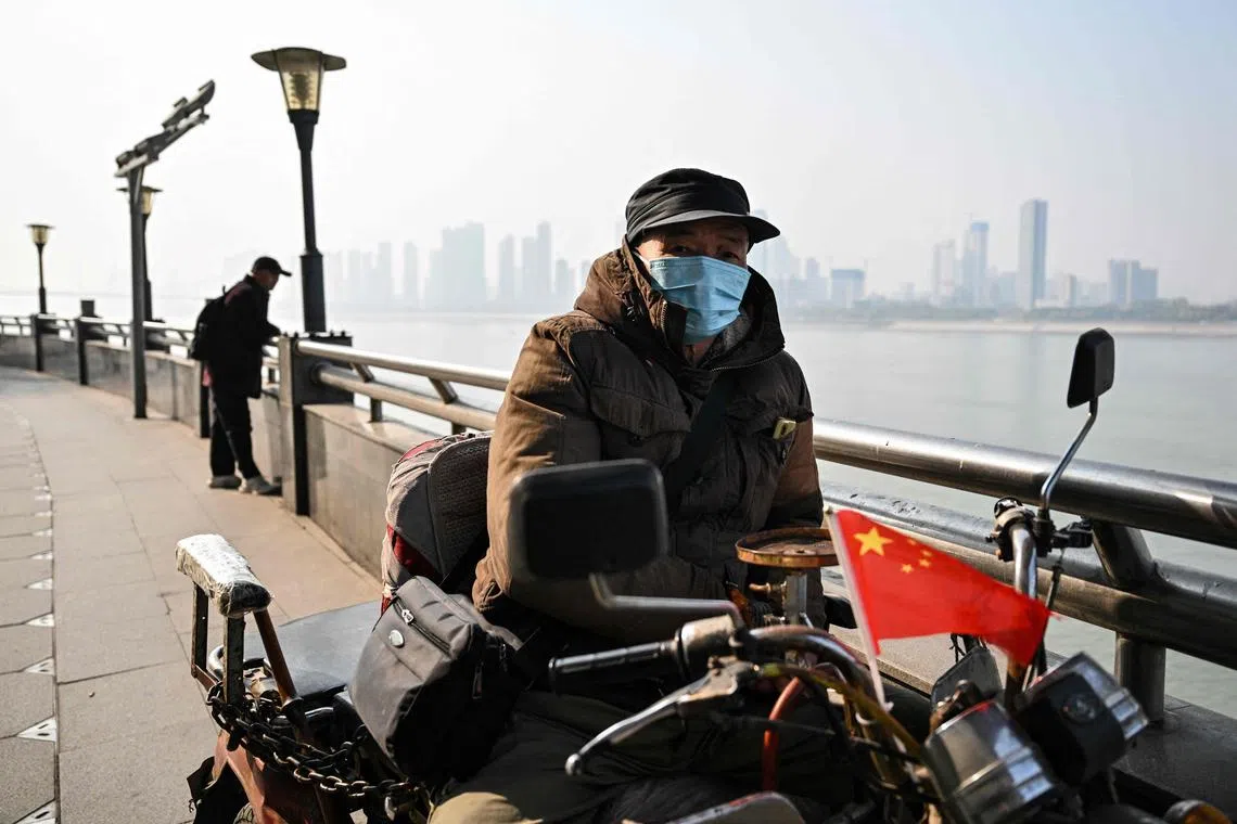 A man taking a rest on a motorcycle next to the Yangtze River in Wuhan - the city where Covid-19 was first detected - ahead of the fifth anniversary of China confirming its first death from the coronavirus.