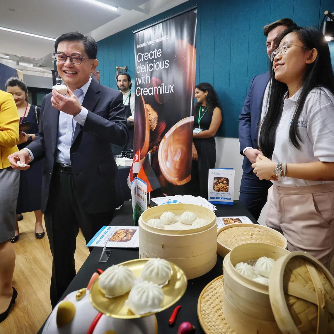 ST20240424_202416587655/ctnnurasa24/Cheryl Tan/Jason Quah
DPM Heng Swee Keat, accompanied by Ms Guo XiuLing (L), CEO, Nurasa, trying out a bun by Cremer at the opening of the Nurasa Food Tech Innovation Centre on 24 Apr, 2024. Looking on is Ms Alina Sng (R), corporate development manager, Cremer.