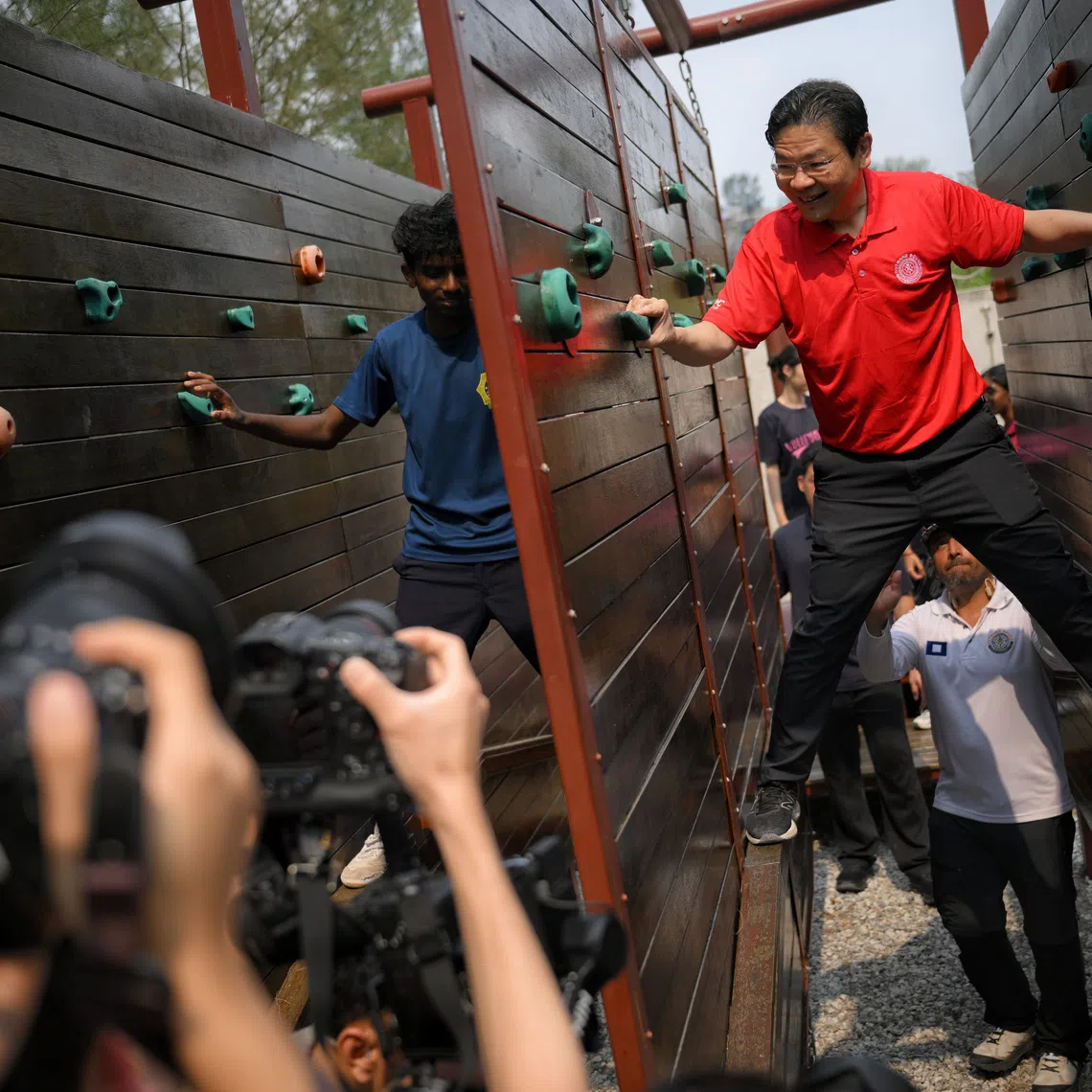 Guest-of-Honour Prime Minister Lawrence Wong (right) manoeuvres an obstacle with students at OBS Coney Campus on Sept 11, 2026.