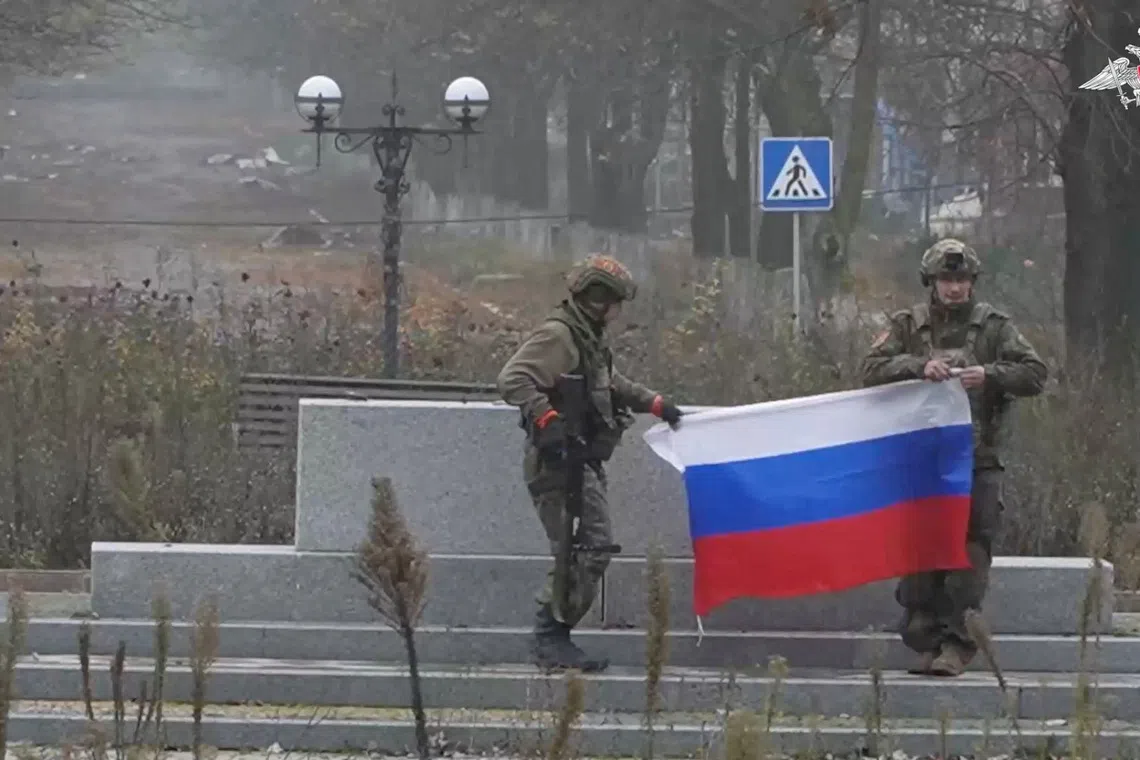 Soldiers hold a Russian flag in Pokrovsk, Donetsk Region, Ukraine, in this screengrab from video released December 1, 2025. Russian Defence Ministry/Handout via REUTERS