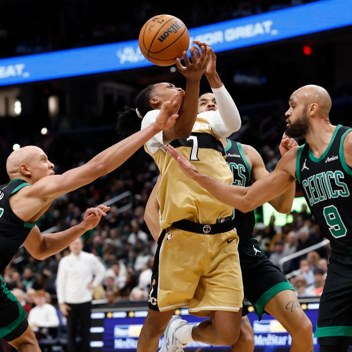 Washington Wizards guard Bub Carrington is fouled while driving to the basket by Boston Celtics guard Jordan Walsh.