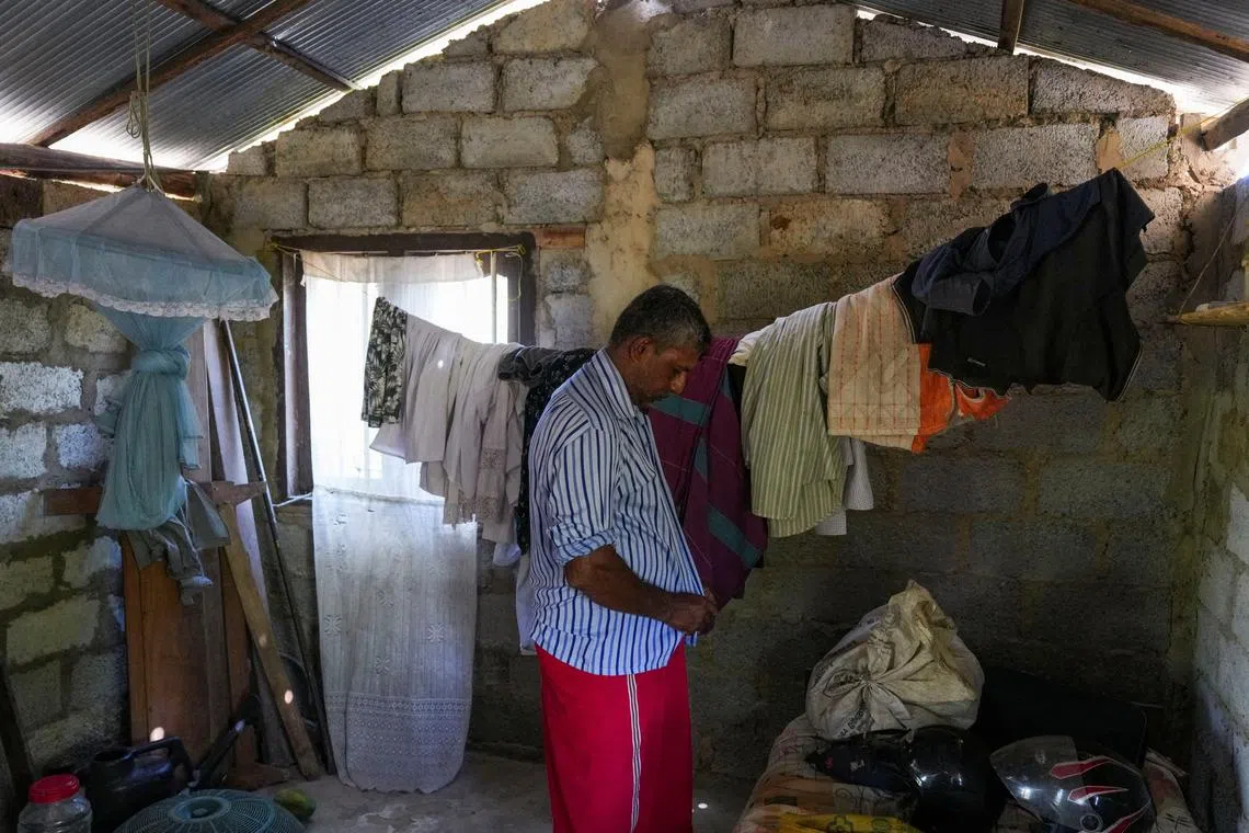 FILE PHOTO: Sudath Kumara, 50, puts on a shirt inside the room of his house in Hambantota, Sri Lanka, October 28, 2024. REUTERS/Thilina Kaluthotage/File Photo