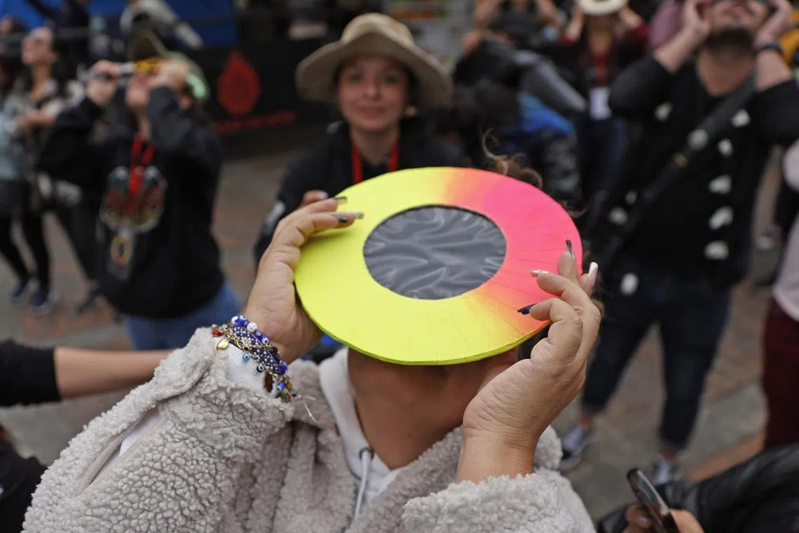 People gathering to observe the solar eclipse at the Planetarium in Bogota, Colombia, on Oct 14, 2023. 