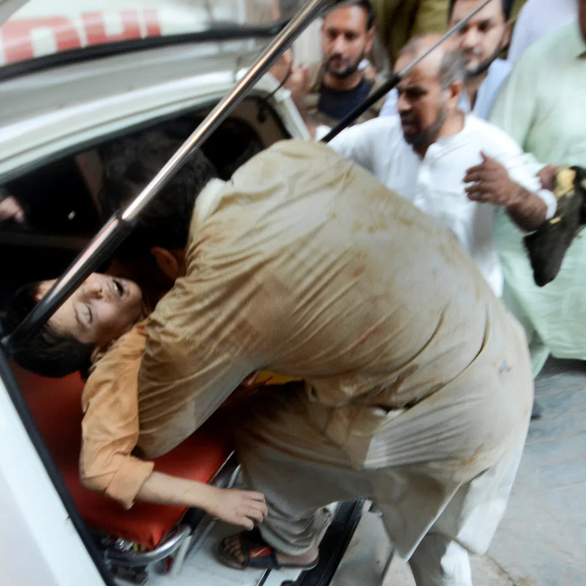 A man carries an injured boy after a school roof collapse in Peshawar, Pakistan, on October 15, 2026. REUTERS