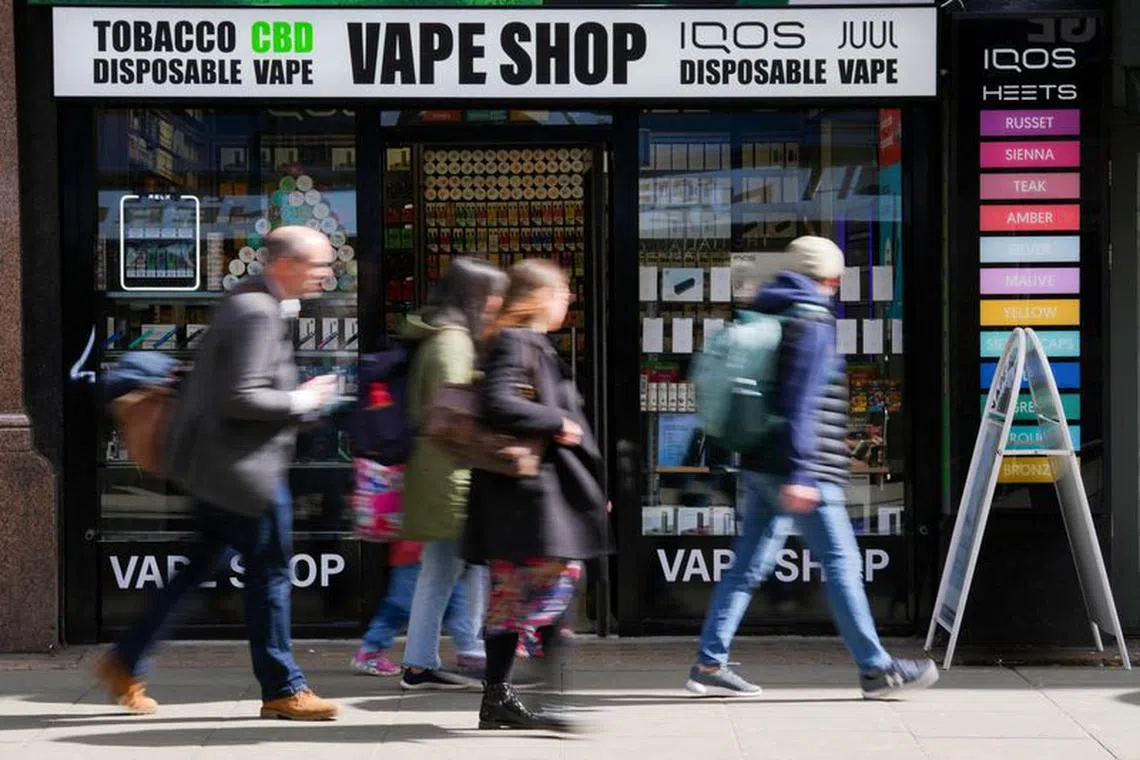 FILE PHOTO: People walk past a Vape Shop in central London, Britain April 11, 2023. REUTERS/Maja Smiejkowska/File Photo