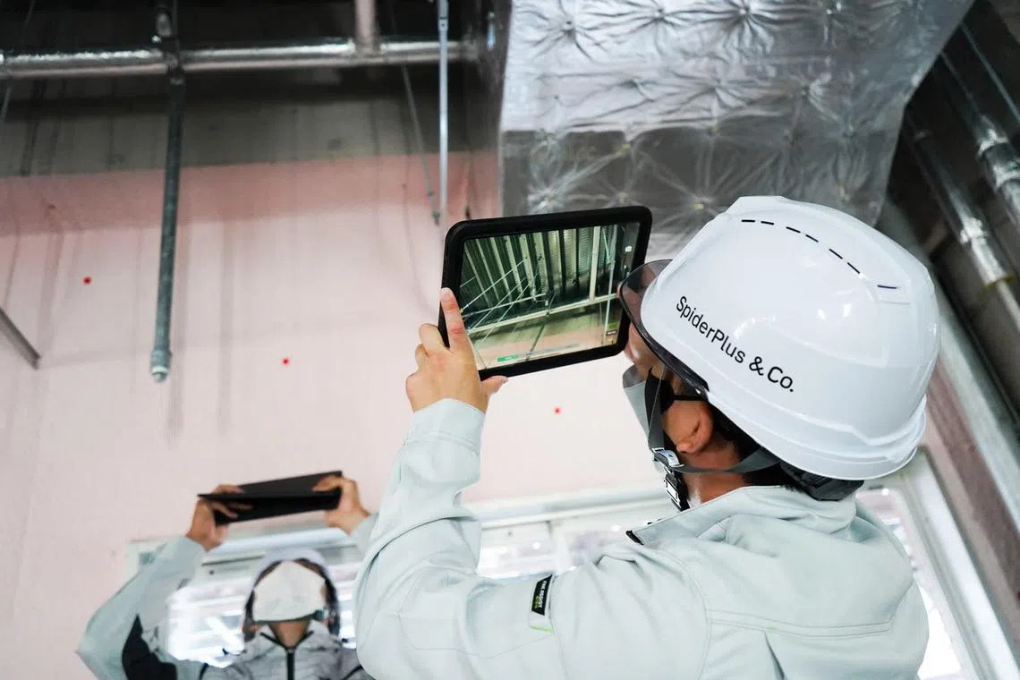A worker capturing photos of a construction site using SpiderPlus and Co's field management app.