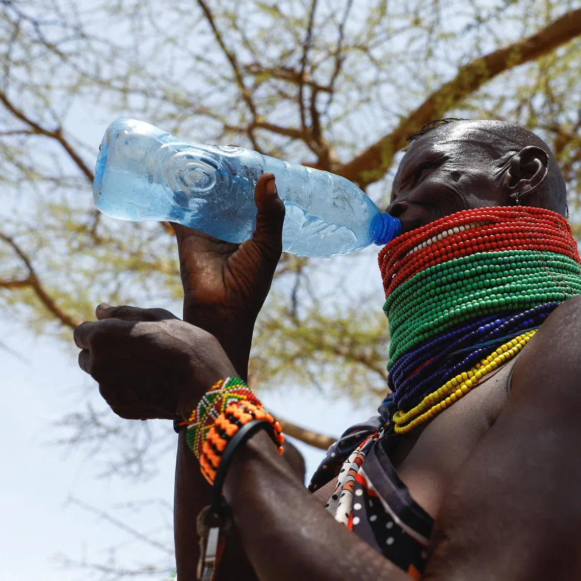 A member of the indigenous Turkana Nilotic community drinks water after arriving at a food distribution centre by the World Food Programme (WFP) following a prolonged dry spell, below-average rainfall causing food insecurity, water scarcity, and livestock losses; to reduce the impact of the ongoing drought situation, providing timely access to nutritious food to the population, at the Kenya Oil village near Lodwar in Turkana County, Kenya February 17, 2026. REUTERS/Thomas Mukoya