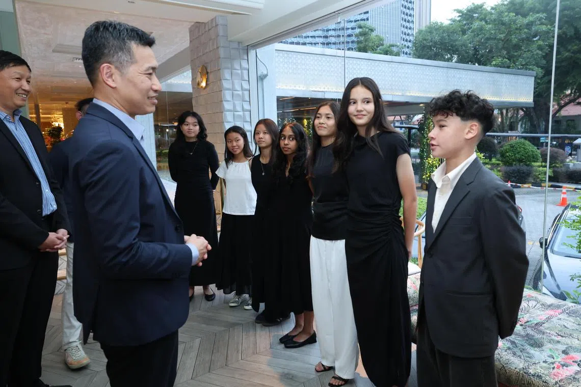 Acting Minister for Culture, Community and Youth David Neo (left) speaking to Edan McCulloch (extreme right) ahead of the UTR scholarship award ceremony.