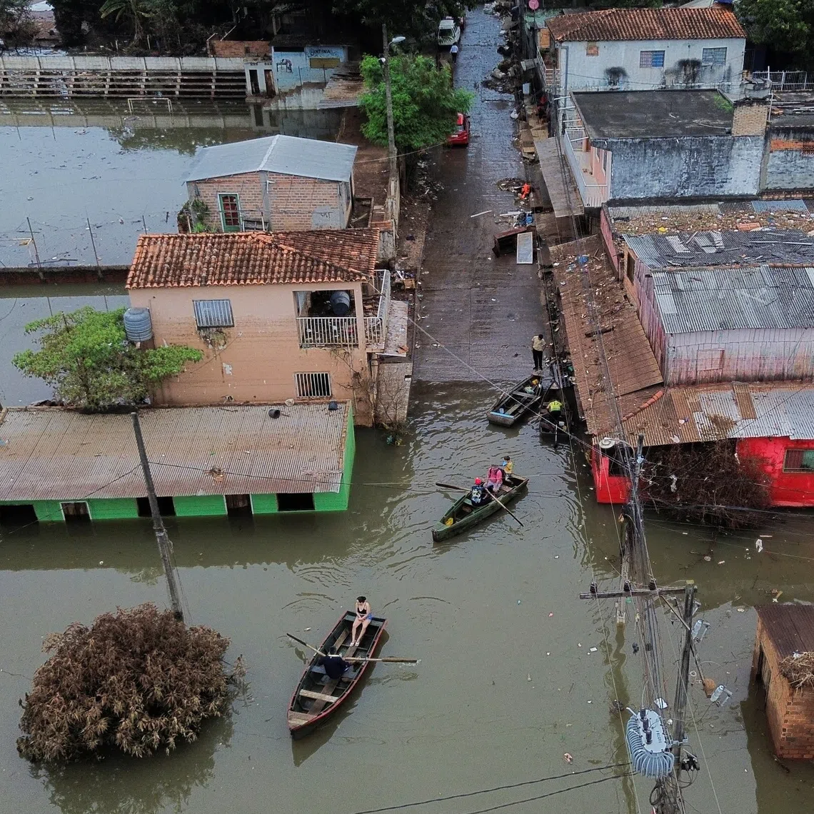 A drone view shows people traveling by boats through a flooded neighborhood after heavy rains, in Ciudad del Este, Paraguay, October 21, 2026. REUTERS/Cesar Olmedo
