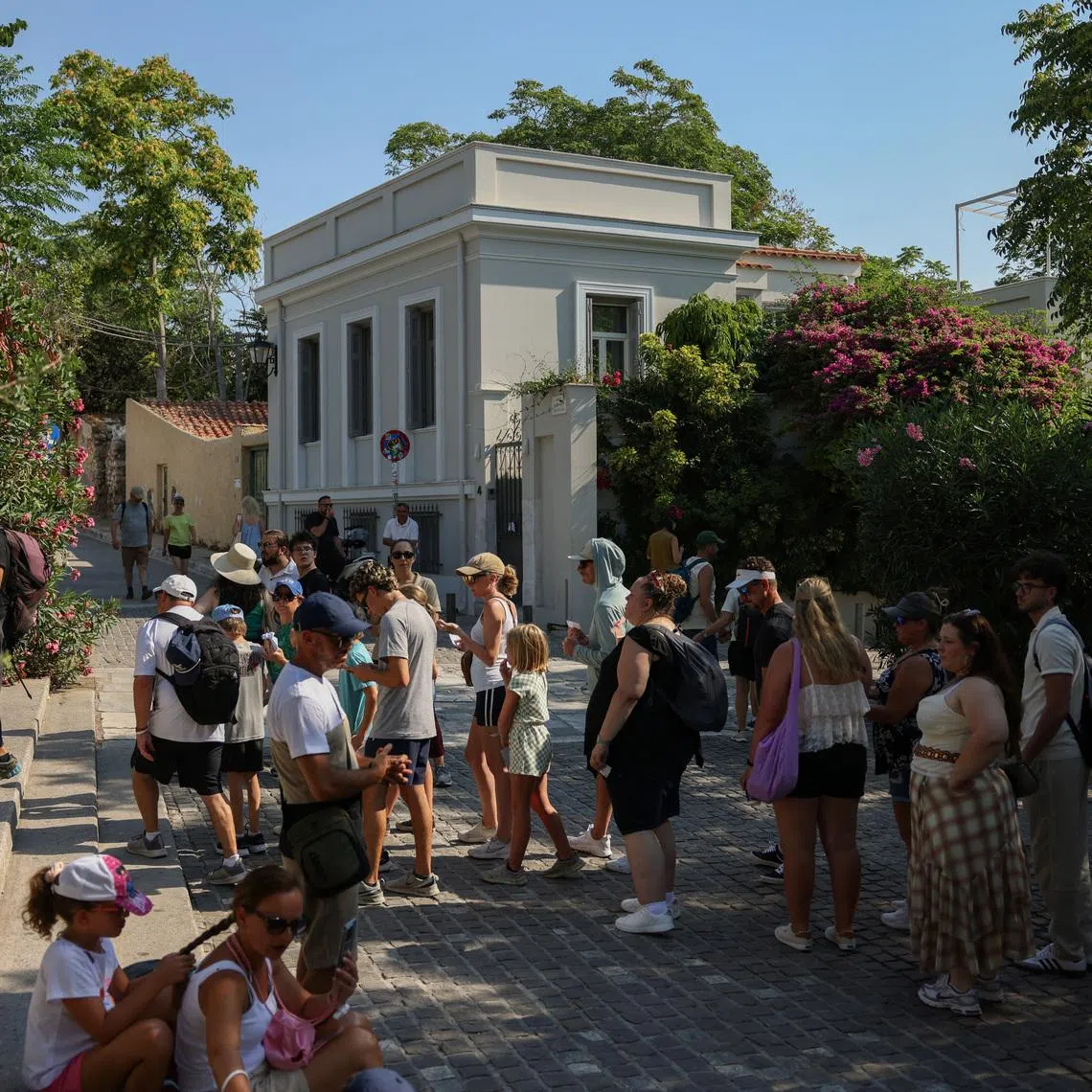Tourists wait in line to enter the Acropolis archaeological site near the location where two American tourists were stabbed in Athens, Greece, July 21, 2026. REUTERS/Louiza Vradi