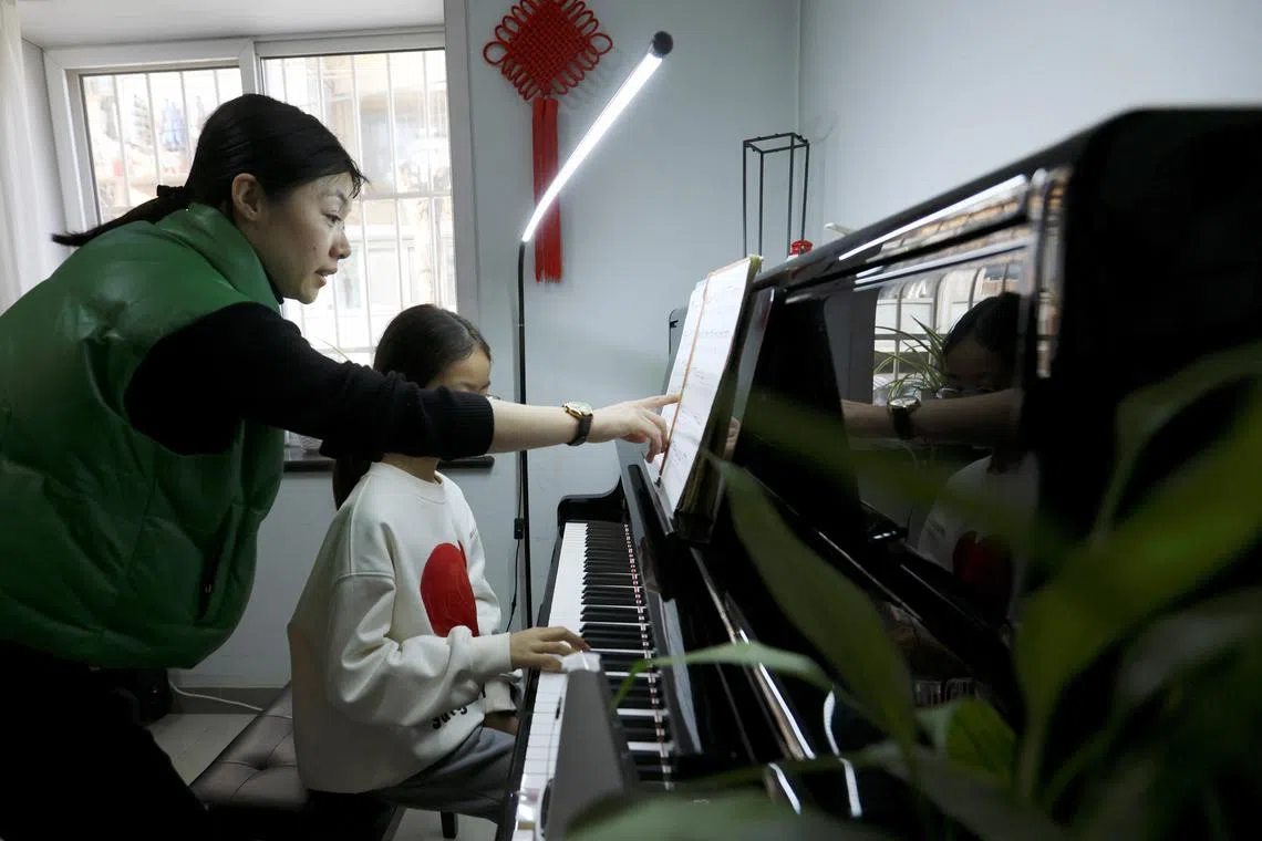 Piano teacher Liu Hongyu conducts a lesson for a student at a classroom in Beijing, China March 12, 2024. REUTERS/Florence Lo