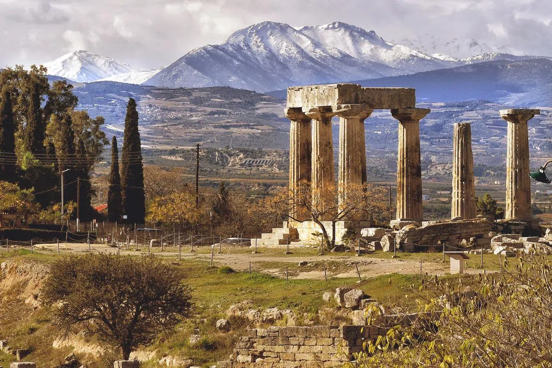 The temple of Apollo with the snowy mountainous Corinthia in the background, Corinth, Greece on Nov 26, 2023. 