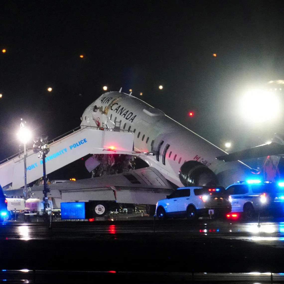 Emergency vehicles are parked near an Air Canada Express jet that had collided with a fire truck at LaGuardia Airport in Queens, New York, U.S. March 23, 2026. REUTERS/Adam Gray