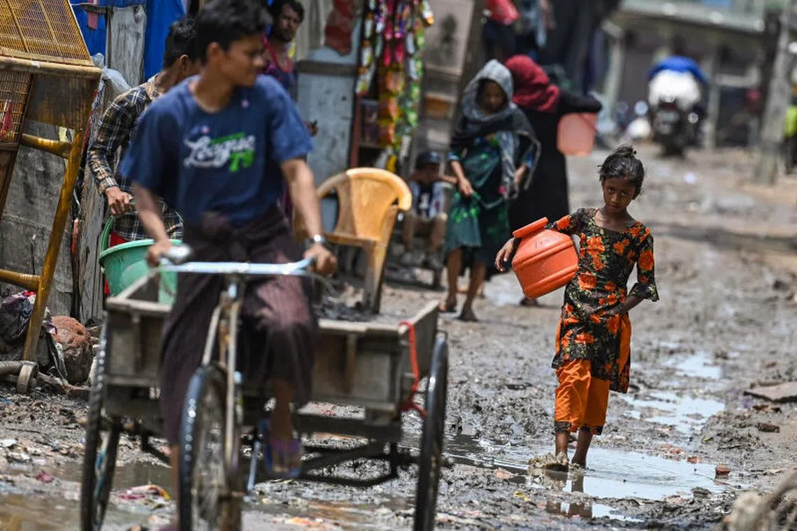 A Rohingya refugee girl walks through a muddy street at a refugee camp in New Delhi, India.