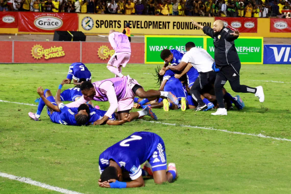 Soccer Football - FIFA World Cup - CONCACAF Qualifiers - Group B - Jamaica v Curacao - National Stadium Independence Park, Kingston, Jamaica - November 18, 2025 Curacao coach Dean Gorre and players celebrate after they qualify for the World Cup REUTERS/Gilbert Bellamy