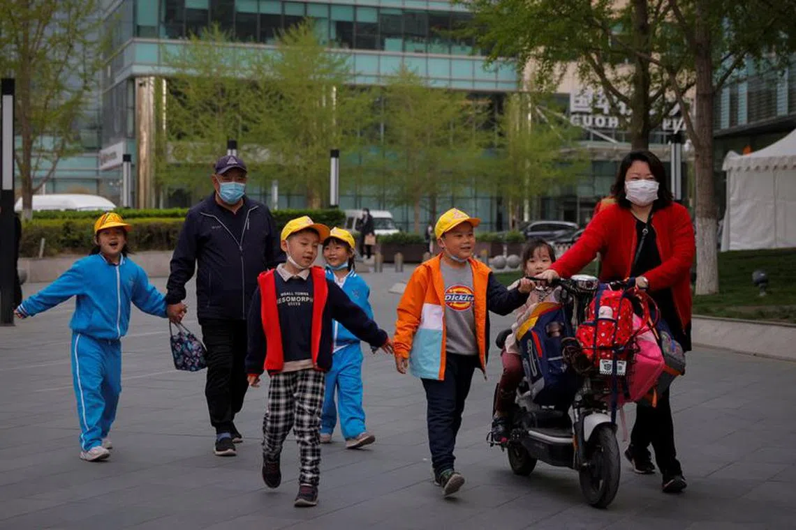 FILE PHOTO: People pick up children from a school in Beijing, China, April 6, 2021. Picture taken April 6, 2021.   REUTERS/Thomas Peter/File Photo