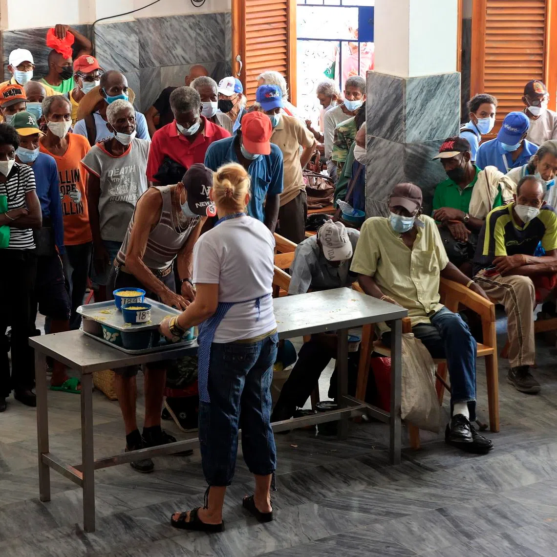 People receive food from staff of the NGO Quisicuaba in Havana on May 25. Experts say instability in Cuba threatens a migration crisis.