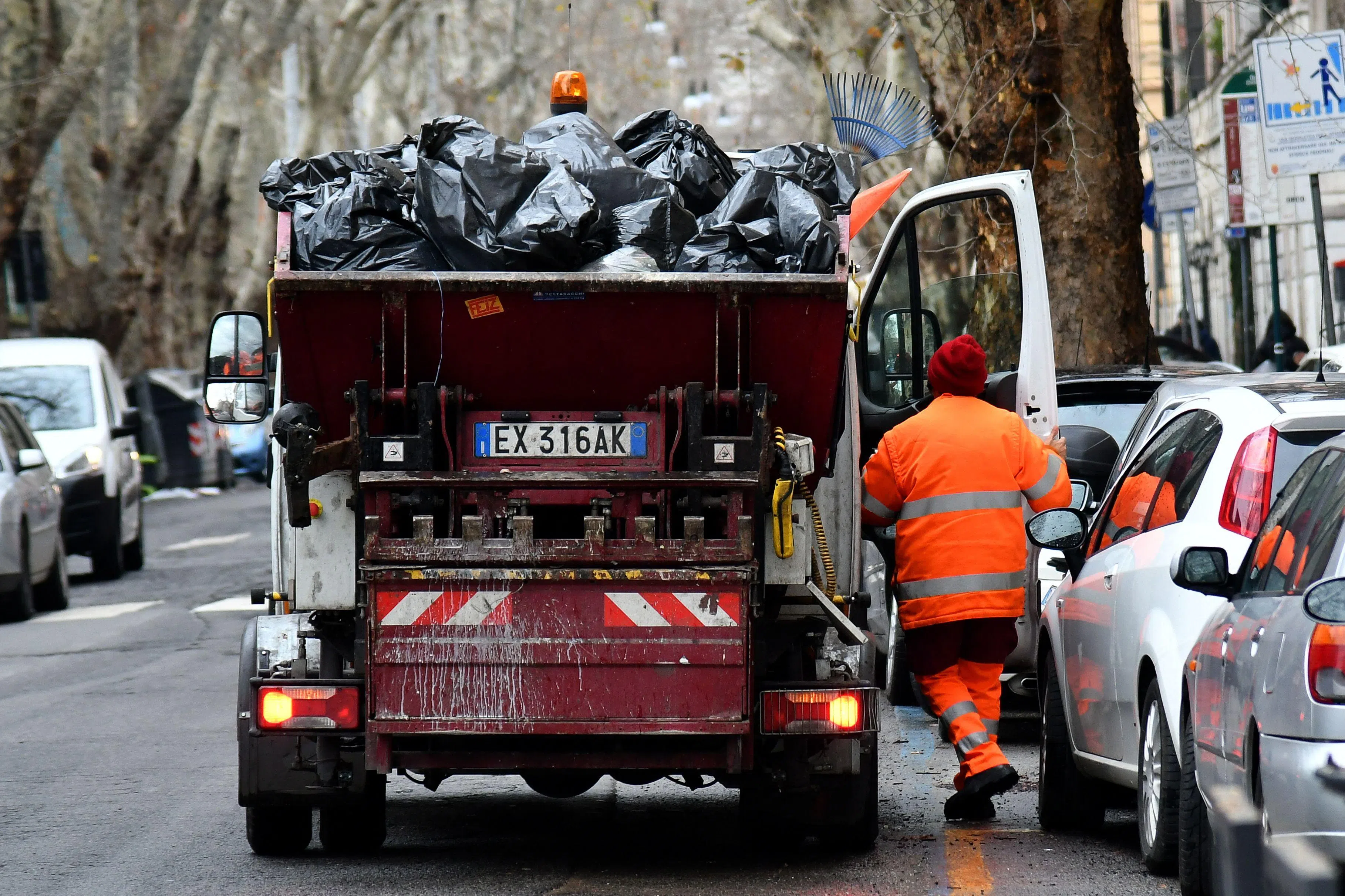 (FILES) This illustration picture shows an employee of Rome's garbage collection "Ama" geting on his truck on January 11, 2018 in Rome. A one-million-euro lottery ticket was found in the rubbish in Italy after the panicked winner asked binmen to help her retrieve it, the waste management company told AFP on August 4, 2026. The ticket was “miraculously still intact” after the binmen combed through mountains of waste in their lorry, Roberto Nicola Toscano, director of the SAMB company in the Puglia region in southern Italy, told AFP. (Photo by Alberto PIZZOLI / AFP)