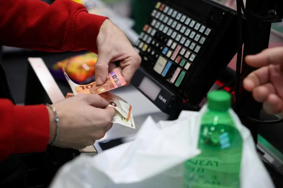A person holds change in euros as customers shop in Fantastico store, on the day of the country’s accession to the Eurozone, in Sofia, Bulgaria, January 1, 2026. REUTERS/Stoyan Nenov