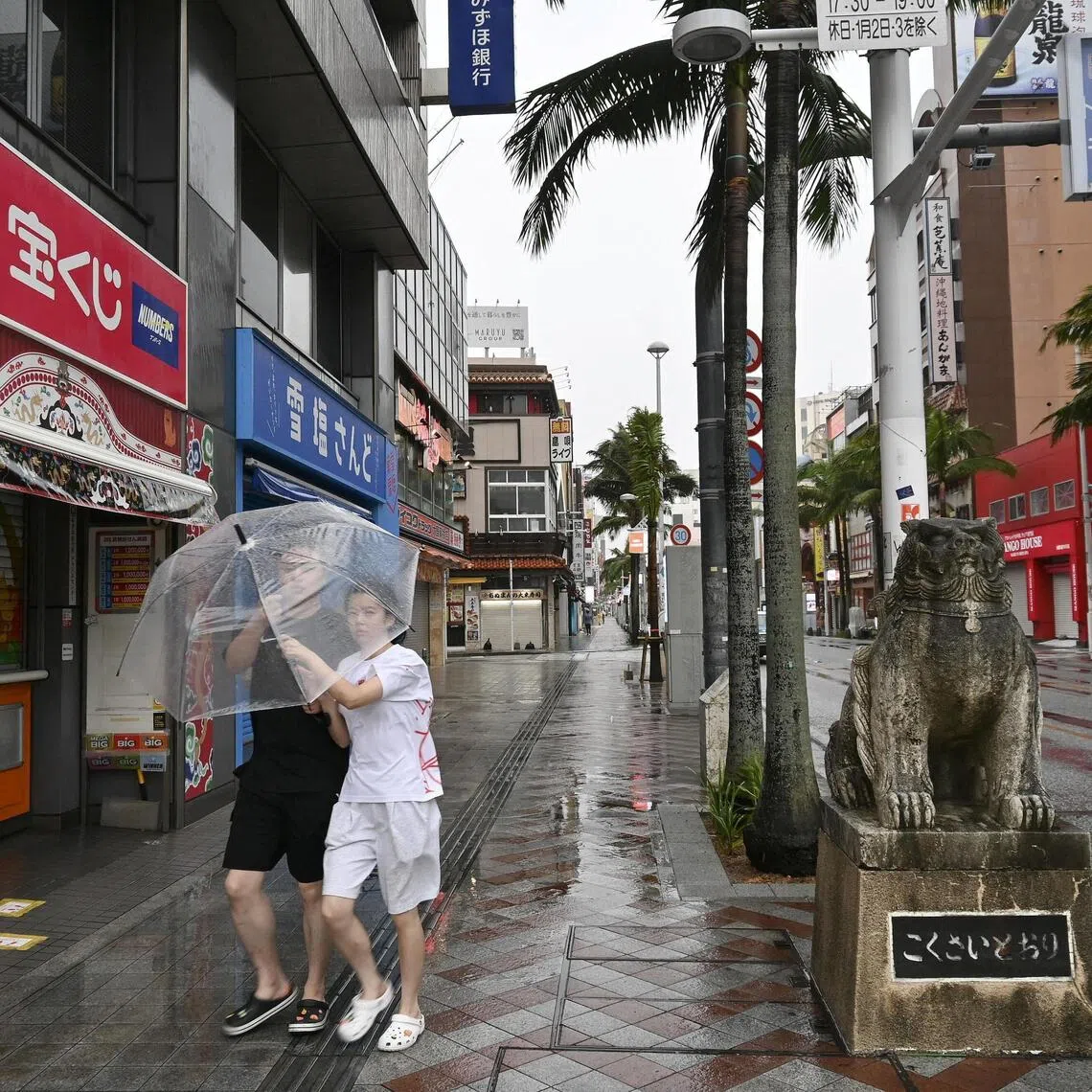 People walk with an umbrella in Naha, Okinawa in Japan.