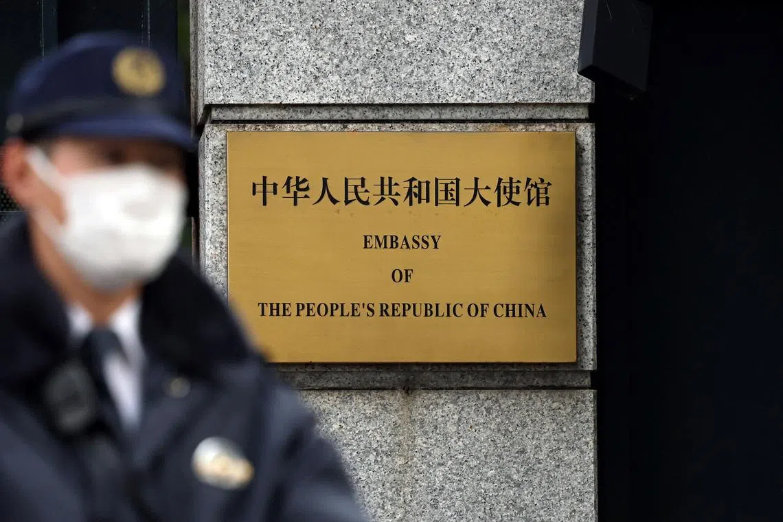 FILE PHOTO: A Japanese police officer stands guard next to a plaque at the entrance of the Chinese embassy in Tokyo, Japan November 18, 2025.  REUTERS/Issei Kato/File Photo