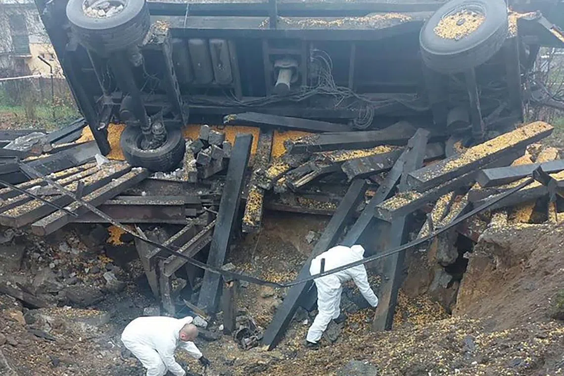 Forensic experts investigate the site where a missile hit in Przewodow.