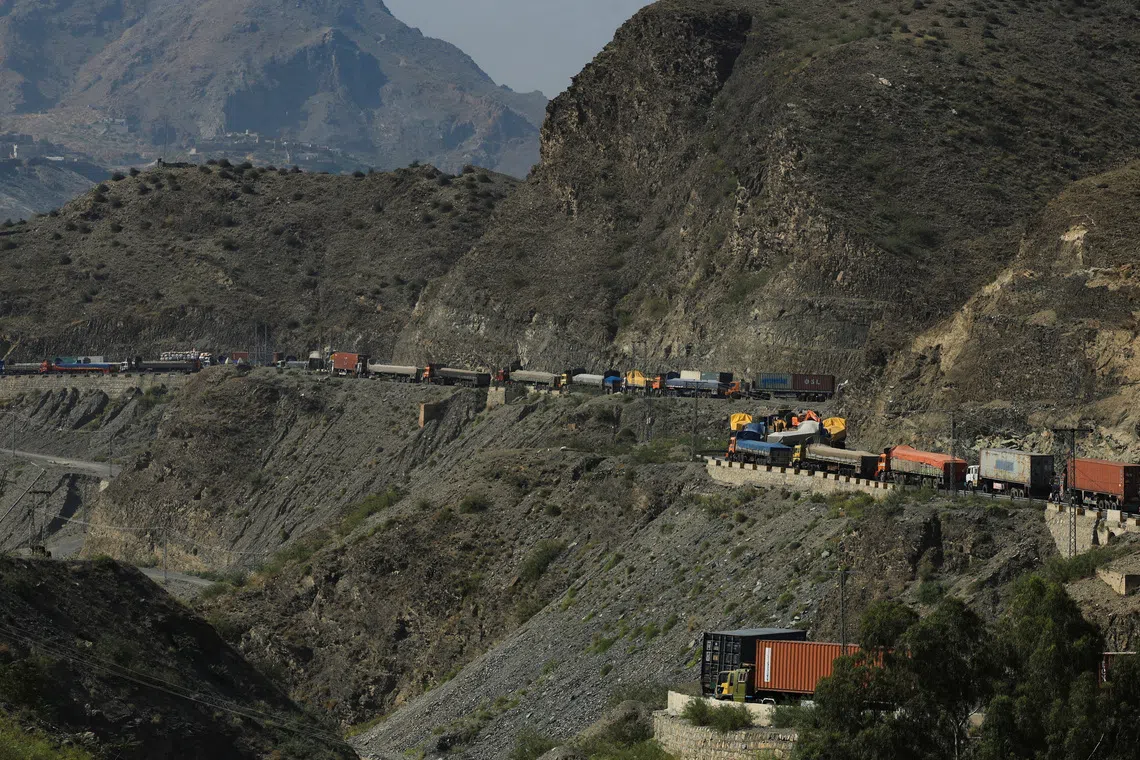Trucks loaded with supplies parking along a road leading to the Torkham border, after Pakistan closed border crossings with Afghanistan, following exchanges of fire between the two nations' forces, in Torkham, Pakistan, on Oct 15, 2025. 