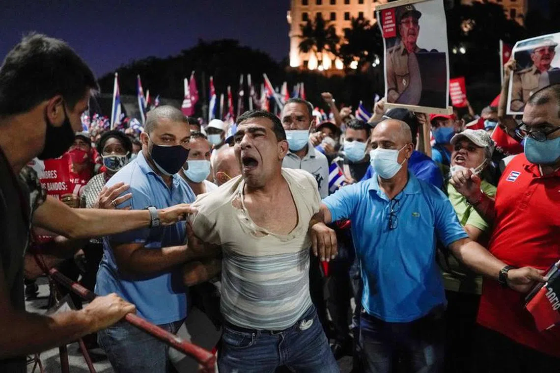 FILE PHOTO: People detain a protester during a rally in Havana, Cuba, July 17, 2021. REUTERS/Alexandre Meneghini