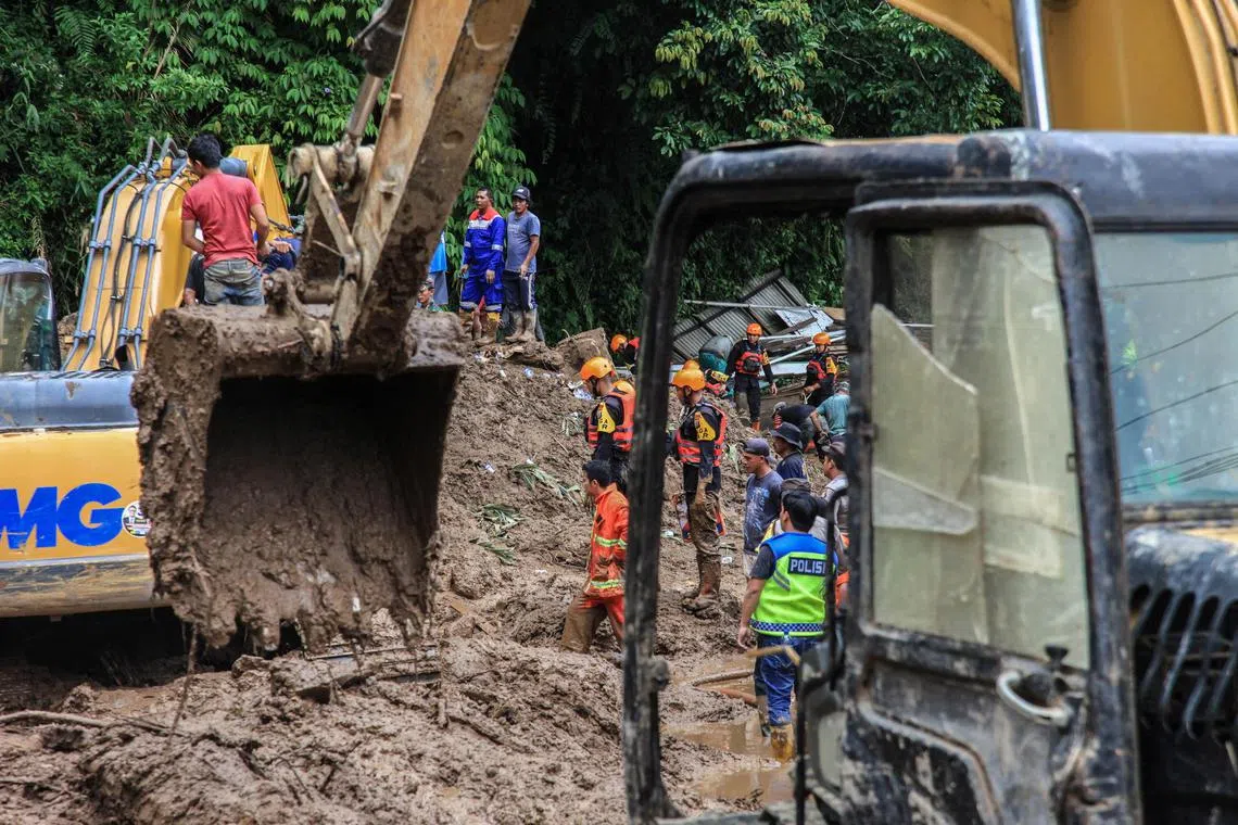 Rescuers search for landslide victims at a village in North Sumatra.