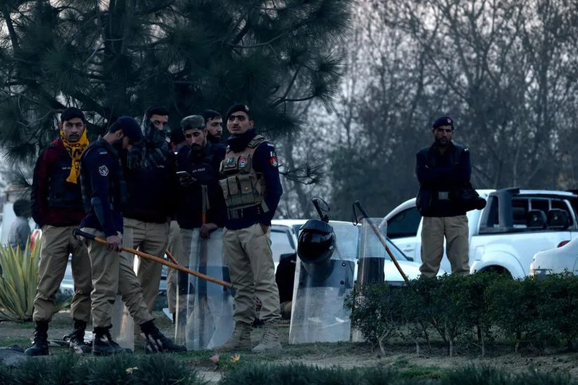 Police officers stand on a road divider as supporters of former Prime Minister Imran Khan's party, the Pakistan Tehreek-e-Insaf (PTI), block the Peshawar-Islamabad motorway as part of their protest demanding free and fair results of the election, in Peshawar, Pakistan, February 11, 2024. REUTERS/Fayaz Aziz/File Photo