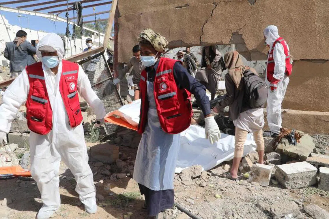 Yemeni rescuers transport the body of a victim from the rubble of a building hit in US strikes, in Saada.