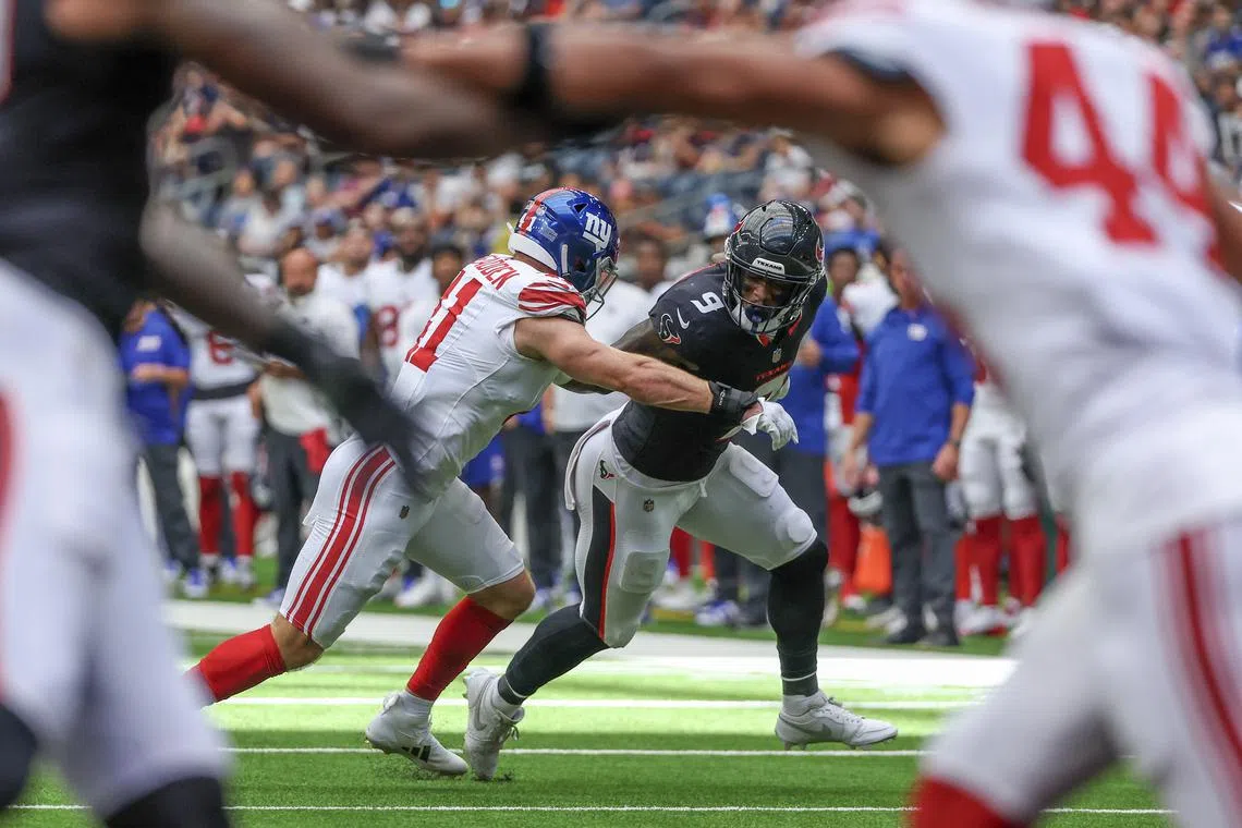 FILE PHOTO: Aug 17, 2024; Houston, Texas, USA; Houston Texans tight end Brevin Jordan (9) stiff arms New York Giants linebacker Micah McFadden (41) in the first quarter at NRG Stadium. Thomas Shea-USA TODAY Sports/File Photo