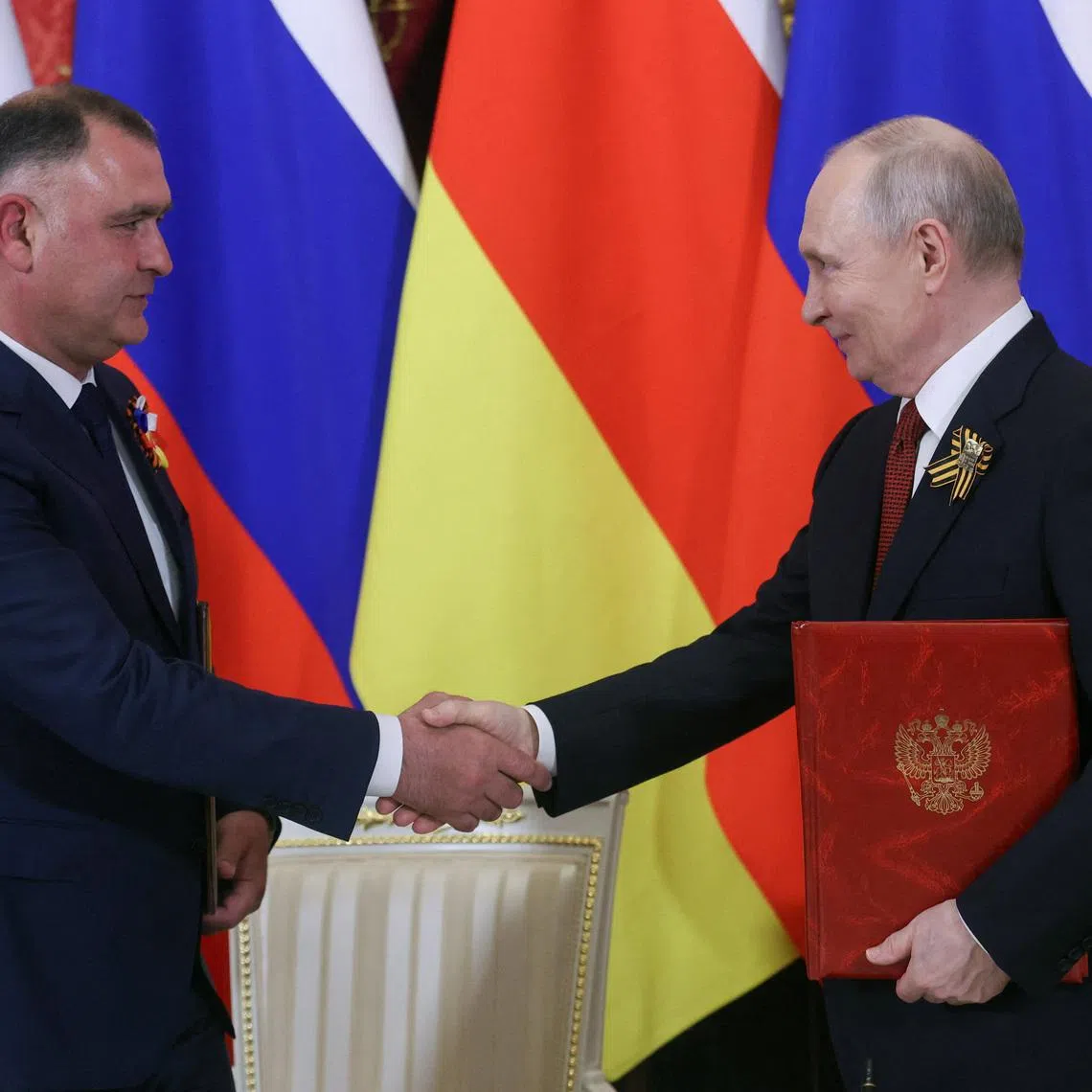 Russian President Vladimir Putin (R) and Alan Gagloyev, President of the breakaway Georgian region of South Ossetia, attend a signing ceremony following a meeting at the Kremlin in Moscow, Russia, May 9, 2026. MAXIM SHIPENKOV/Pool via REUTERS